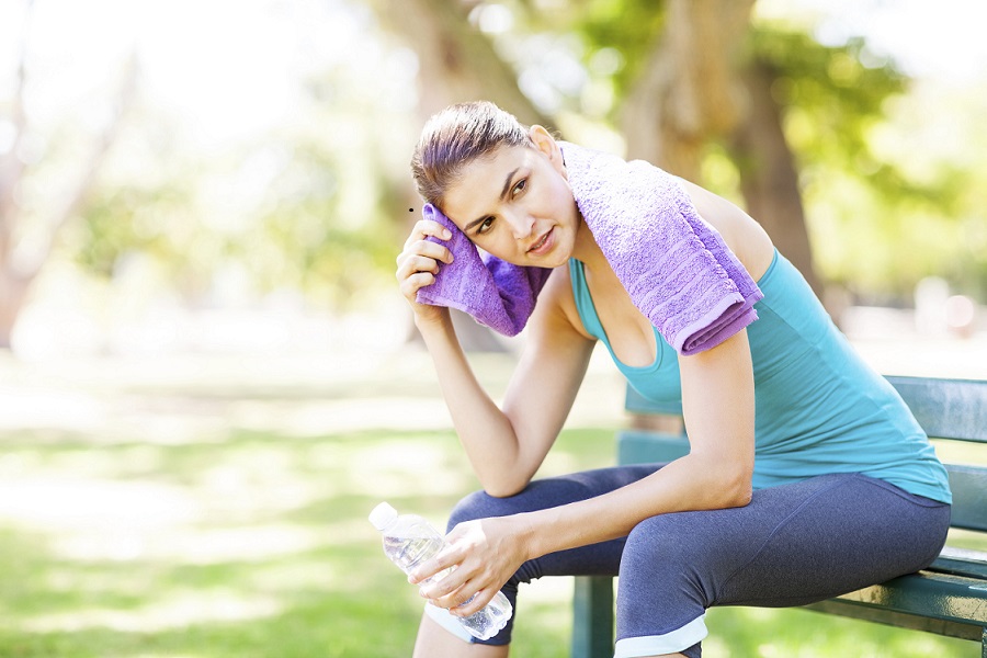 Sporty Woman Wiping Sweat On Park Bench