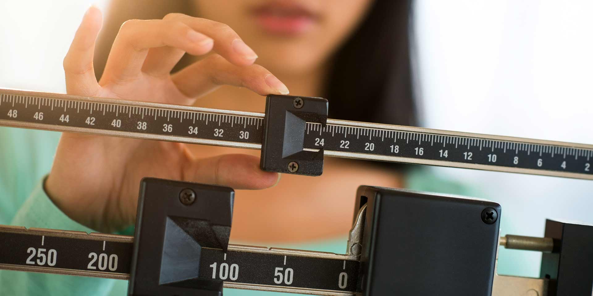 Woman checking weight on a scale.