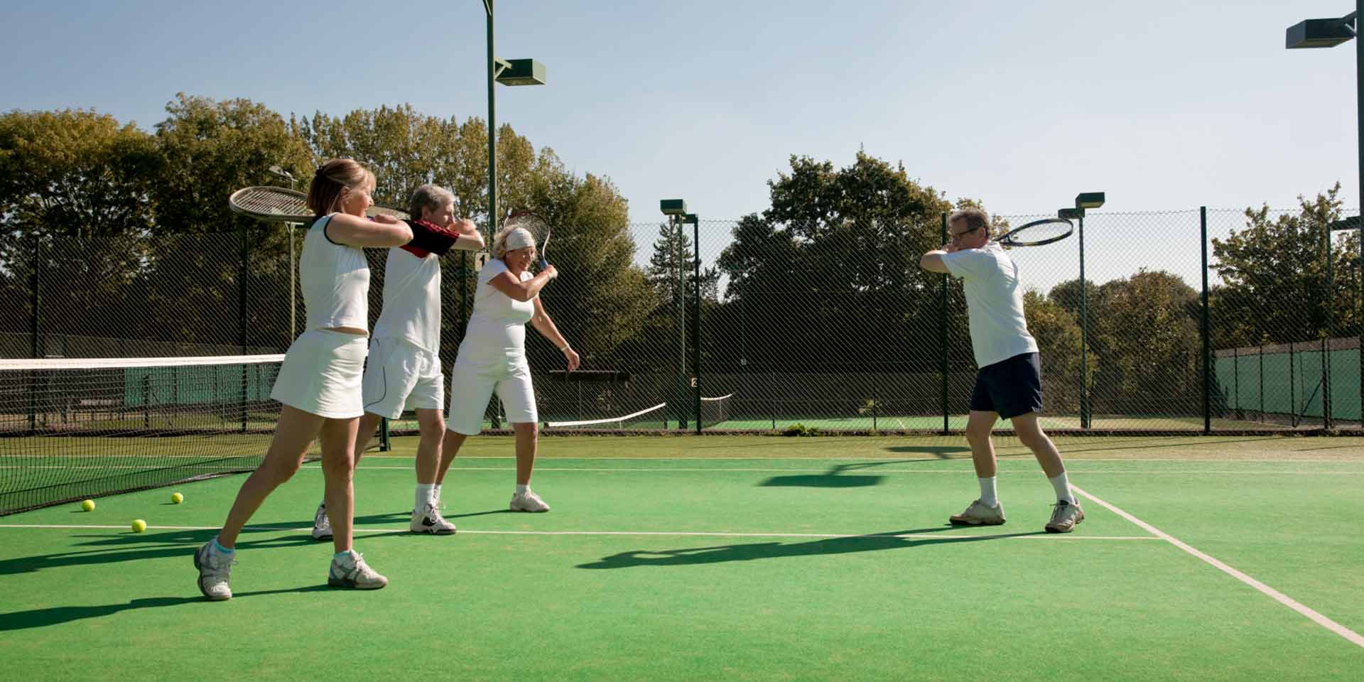 Group of people learning how to play tennis