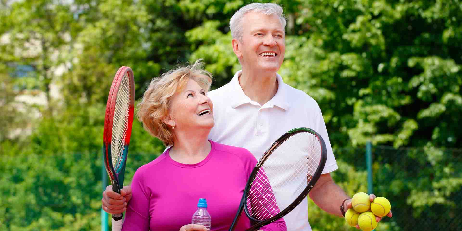 Couple holding tennis rackets.